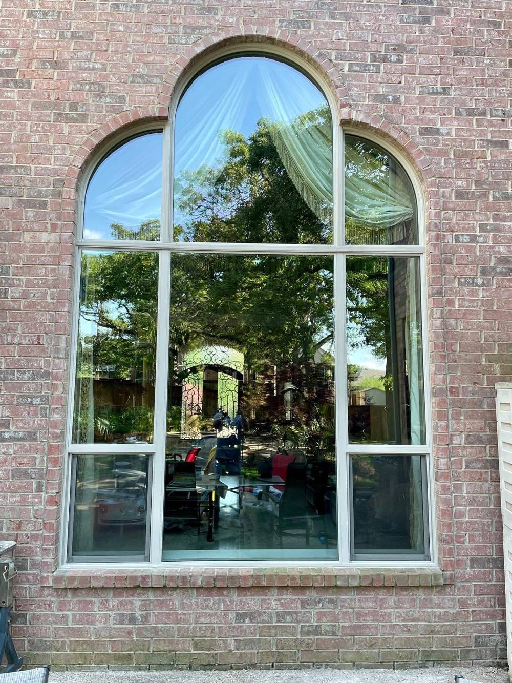 A tall arched window with clear radius-top glass and no grids
