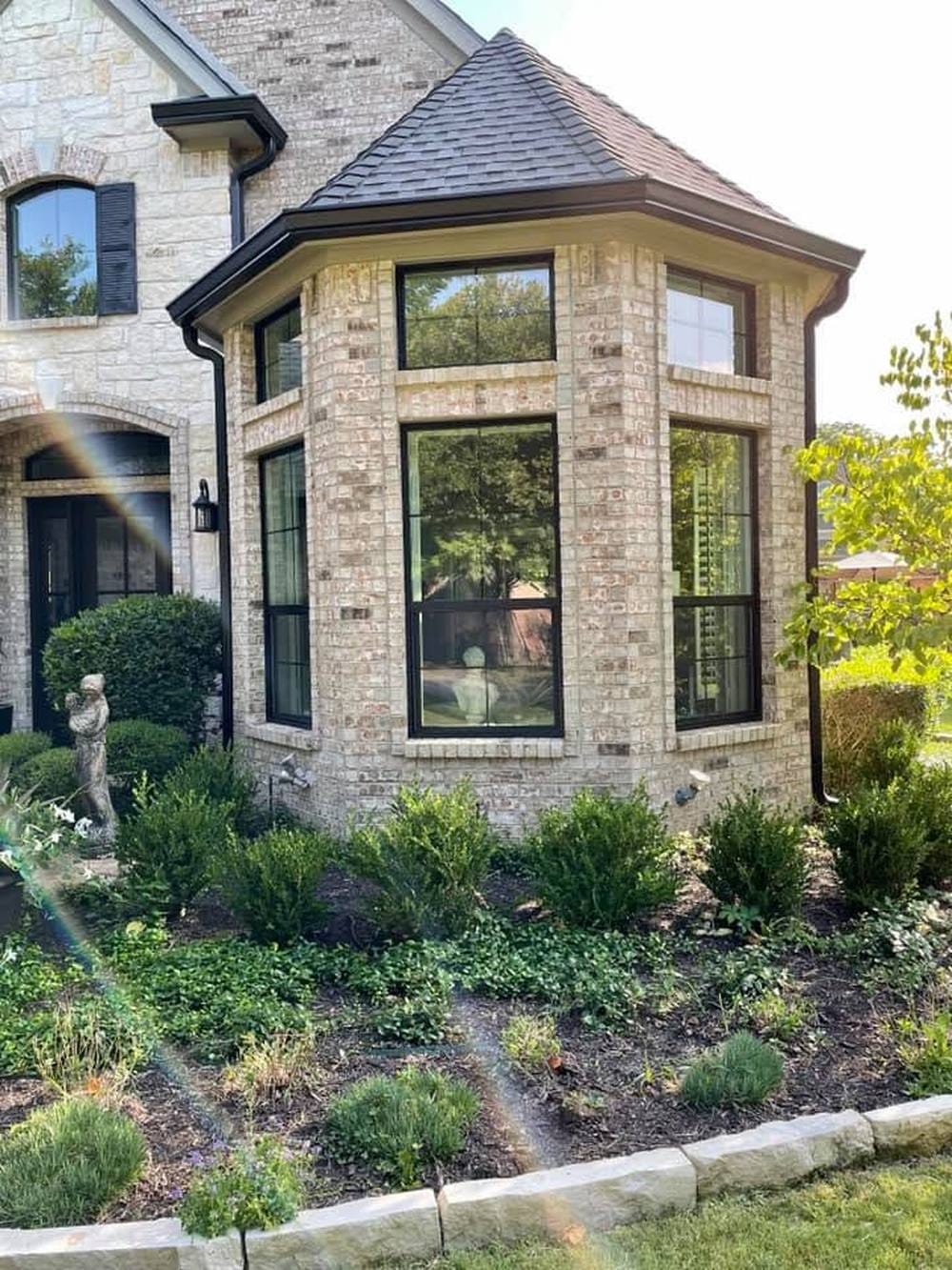 A two-story bay window rebuilt with black frames and unbroken glass