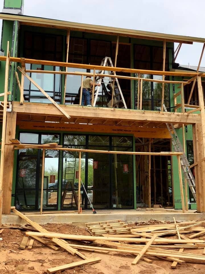 Crew installing large windows and a patio door on new construction